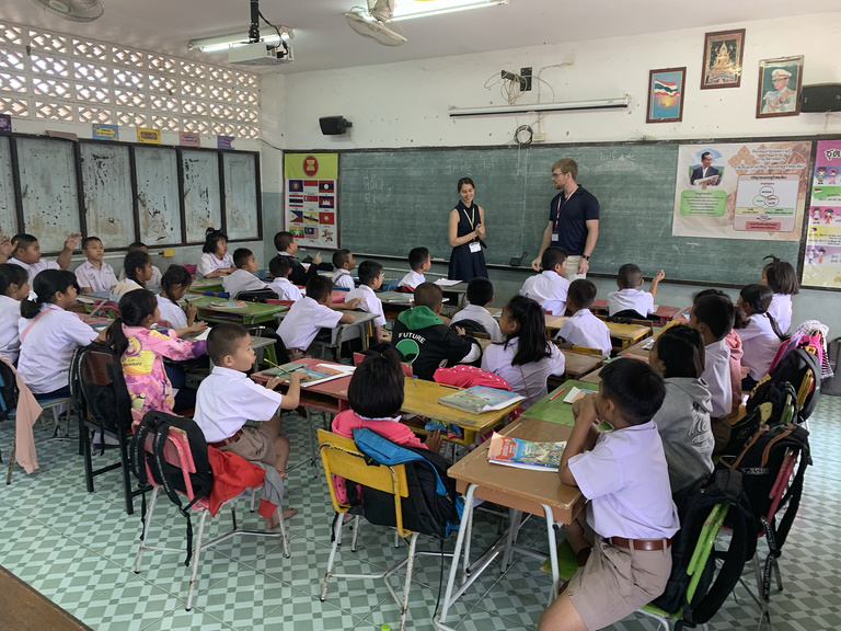 Two adults teaching kids in Thailand classroom