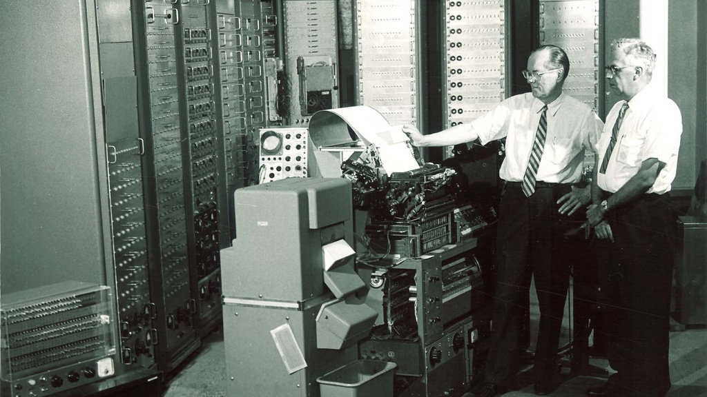 Antique photo of E.F. Lindquist standing by room-sized computer